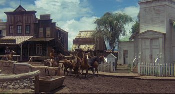 Movie still from “The Last Movie” (1971), directed by Dennis Hopper – A group of people riding horses down a dirt road; Extreme Wide shot, Low angle