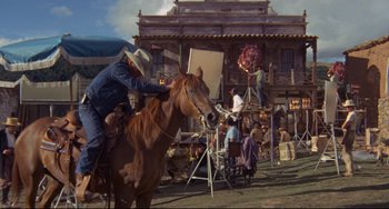 Movie still from “The Last Movie” (1971), directed by Dennis Hopper – A man riding a horse in front of a movie set; Wide shot, Low angle