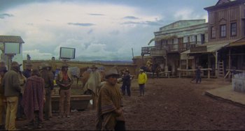 Movie still from “The Last Movie” (1971), directed by Dennis Hopper – A group of people standing in a dirt field; Wide shot, High angle