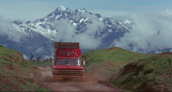 Movie still from “The Last Movie” (1971), directed by Dennis Hopper – A truck driving down a dirt road near a mountain range; Extreme Wide shot, Low angle
