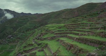 Movie still from “The Last Movie” (1971), directed by Dennis Hopper – A view of a grassy field with a mountain in the background; Extreme Wide shot, High angle