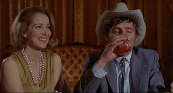 Movie still from “The Last Movie” (1971), directed by Dennis Hopper – A man and a woman sitting at a table; Medium shot, Low angle