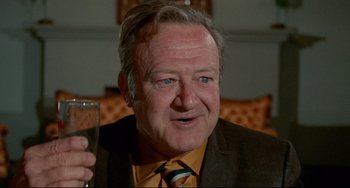 Movie still from “The Last Movie” (1971), directed by Dennis Hopper – An older man holding a glass of champagne; Close Up shot, Low angle