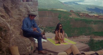 Movie still from “The Last Movie” (1971), directed by Dennis Hopper – A man and a woman sitting on the side of a cliff; Wide shot, High angle