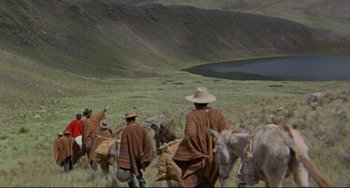 Movie still from “The Last Movie” (1971), directed by Dennis Hopper – A group of people in a field with horses; Extreme Wide shot, High angle