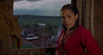 Movie still from “The Last Movie” (1971), directed by Dennis Hopper – A woman standing on top of a building looking at the camera; Medium shot, Over the shoulder angle