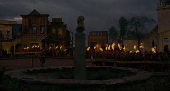 Movie still from “The Last Movie” (1971), directed by Dennis Hopper – A crowd of people standing in front of buildings; Extreme Wide shot, High angle