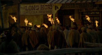 Movie still from “The Last Movie” (1971), directed by Dennis Hopper – A group of people are gathered outside of a store; Extreme Wide shot, High angle