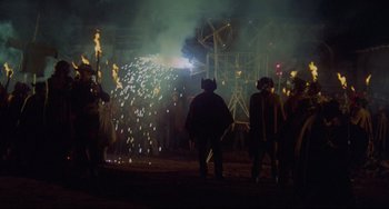 Movie still from “The Last Movie” (1971), directed by Dennis Hopper – A group of people standing in front of fireworks; Extreme Wide shot, High angle