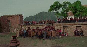 Movie still from “The Last Movie” (1971), directed by Dennis Hopper – A group of people standing on top of a stone wall; Extreme Wide shot, High angle
