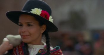Movie still from “The Last Movie” (1971), directed by Dennis Hopper – A woman wearing a black hat with flowers on top of her head; Close Up shot, Low angle