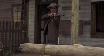 Movie still from “The Last Movie” (1971), directed by Dennis Hopper – A man with a hat and a gun in his hand; Medium shot, Low angle