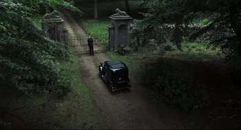 Movie still from “The Little Stranger” (2018), directed by Lenny Abrahamson – A man standing in front of a car in a driveway; Extreme Wide shot, High angle