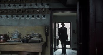 Movie still from “The Little Stranger” (2018), directed by Lenny Abrahamson – A man holding a briefcase walking through a doorway; Wide shot, Low angle