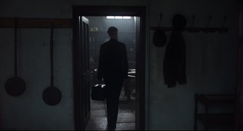 Movie still from “The Little Stranger” (2018), directed by Lenny Abrahamson – A man in a suit is walking through a doorway; Wide shot, Over the shoulder angle