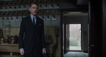 Movie still from “The Little Stranger” (2018), directed by Lenny Abrahamson – A man in a suit and tie standing in front of an open door; Medium shot, Low angle