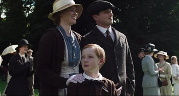 Movie still from “The Little Stranger” (2018), directed by Lenny Abrahamson – A man and a woman standing next to a young boy; Medium shot, Low angle