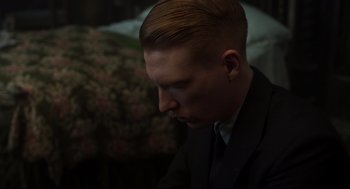 Movie still from “The Little Stranger” (2018), directed by Lenny Abrahamson – A person wearing a suit and tie; Close Up shot, High angle