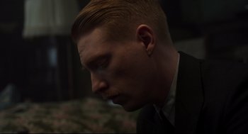Movie still from “The Little Stranger” (2018), directed by Lenny Abrahamson – A person wearing a suit and tie; Close Up shot, Low angle
