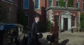 Movie still from “The Little Stranger” (2018), directed by Lenny Abrahamson – A man and a woman standing next to each other; Wide shot, Over the shoulder angle
