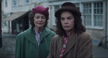 Movie still from “The Little Stranger” (2018), directed by Lenny Abrahamson – Two women standing next to each other wearing hats; Medium shot, Low angle