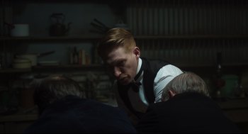 Movie still from “The Little Stranger” (2018), directed by Lenny Abrahamson – A man in a white shirt and a black tie; Medium shot, Over the shoulder angle