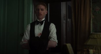 Movie still from “The Little Stranger” (2018), directed by Lenny Abrahamson – A man in a black vest and a bow tie; Medium shot, Low angle