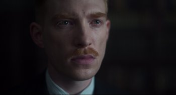 Movie still from “The Little Stranger” (2018), directed by Lenny Abrahamson – A person wearing a suit and tie; Close Up shot, Low angle