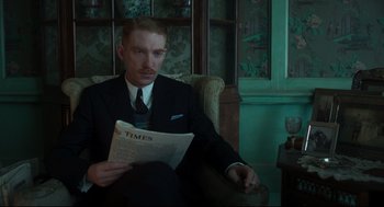 Movie still from “The Little Stranger” (2018), directed by Lenny Abrahamson – A man in a suit and tie sitting in a chair; Medium shot, Over the shoulder angle