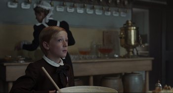 Movie still from “The Little Stranger” (2018), directed by Lenny Abrahamson – A young boy in front of a large bowl of food; Medium shot, Over the shoulder angle
