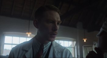 Movie still from “The Little Stranger” (2018), directed by Lenny Abrahamson – A man in a white lab coat and a red tie; Close Up shot, Low angle