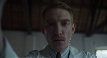 Movie still from “The Little Stranger” (2018), directed by Lenny Abrahamson – A person wearing a suit and tie; Close Up shot, Low angle