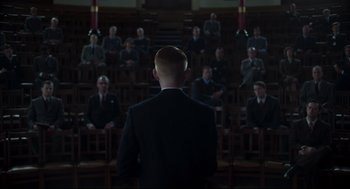 Movie still from “The Little Stranger” (2018), directed by Lenny Abrahamson – A man standing in front of a group of people; Wide shot, High angle