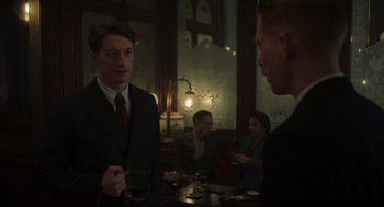 Movie still from “The Little Stranger” (2018), directed by Lenny Abrahamson – A man in a suit is talking to another man in a suit; Medium shot, Over the shoulder angle