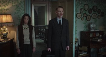 Movie still from “The Little Stranger” (2018), directed by Lenny Abrahamson – A man and a woman standing in front of a door; Medium shot, Low angle
