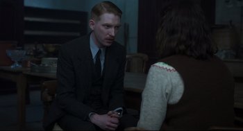 Movie still from “The Little Stranger” (2018), directed by Lenny Abrahamson – A man in a suit is sitting next to a woman in a sweater; Medium shot, Over the shoulder angle