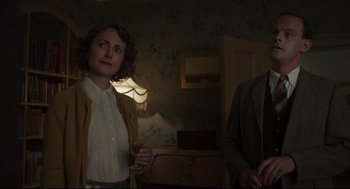 Movie still from “The Little Stranger” (2018), directed by Lenny Abrahamson – A woman standing next to a man holding a wine glass; Medium shot, Over the shoulder angle