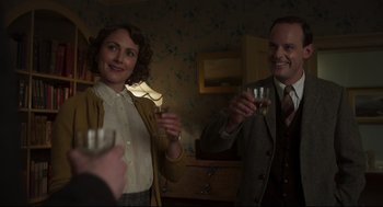 Movie still from “The Little Stranger” (2018), directed by Lenny Abrahamson – A man and a woman are holding wine glasses; Medium shot, Over the shoulder angle