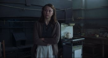 Movie still from “The Little Stranger” (2018), directed by Lenny Abrahamson – A woman standing in front of an oven in a kitchen; Medium shot, Low angle