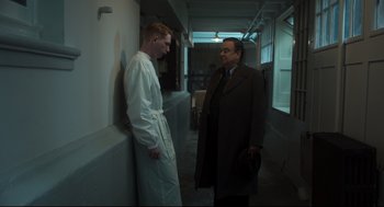 Movie still from “The Little Stranger” (2018), directed by Lenny Abrahamson – Two men standing next to each other in a hallway; Medium shot, Over the shoulder angle