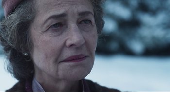 Movie still from “The Little Stranger” (2018), directed by Lenny Abrahamson – An older woman looking at the camera with a sad look on her face; Close Up shot, Over the shoulder angle