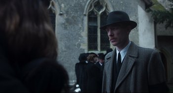 Movie still from “The Little Stranger” (2018), directed by Lenny Abrahamson – A man wearing a hat and a suit and tie; Medium shot, Over the shoulder angle