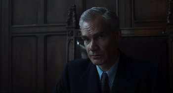 Movie still from “The Little Stranger” (2018), directed by Lenny Abrahamson – A person wearing a suit and tie; Close Up shot, Low angle