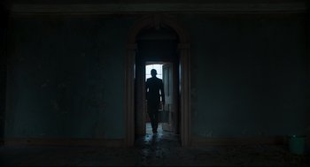 Movie still from “The Little Stranger” (2018), directed by Lenny Abrahamson – A man standing in front of an open door; Wide shot, Low angle