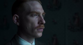 Movie still from “The Little Stranger” (2018), directed by Lenny Abrahamson – A person wearing a suit and tie; Close Up shot, Low angle