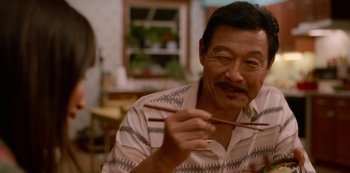 Movie still from “Always Be My Maybe” (2019), directed by Nahnatchka Khan – An older man holding chopsticks in his hands; Close Up shot, Over the shoulder angle