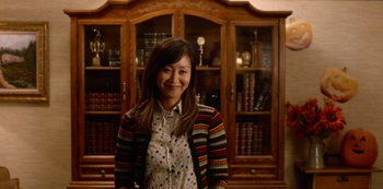 Movie still from “Always Be My Maybe” (2019), directed by Nahnatchka Khan – A woman standing in front of a wooden bookcase; Medium shot, Over the shoulder angle