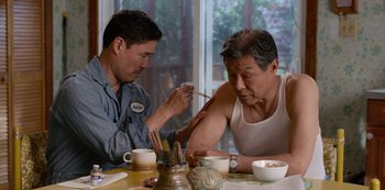 Movie still from “Always Be My Maybe” (2019), directed by Nahnatchka Khan – Two men sitting at a dining room table; Medium shot, Over the shoulder angle
