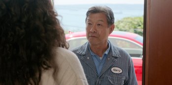 Movie still from “Always Be My Maybe” (2019), directed by Nahnatchka Khan – An older man wearing a denim jacket talking to a woman; Medium shot, Over the shoulder angle