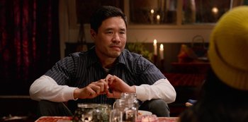 Movie still from “Always Be My Maybe” (2019), directed by Nahnatchka Khan – A man sitting at a table with a candle in the background; Close Up shot, Over the shoulder angle